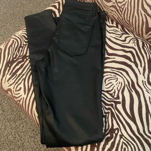 Black coated jeans, leather look.